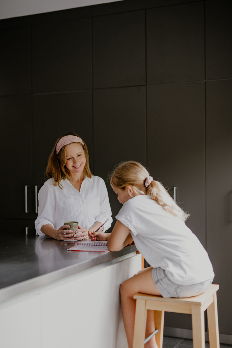 mother and daughter sitting at kitchen bench